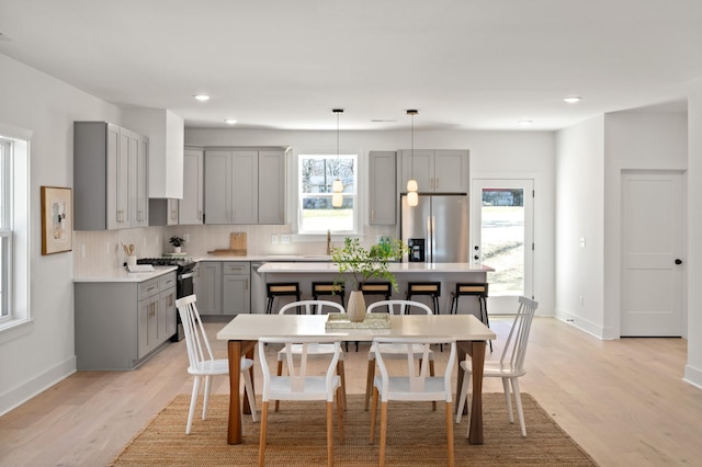 kitchen featuring appliances with stainless steel finishes, gray cabinetry, a healthy amount of sunlight, and tasteful backsplash