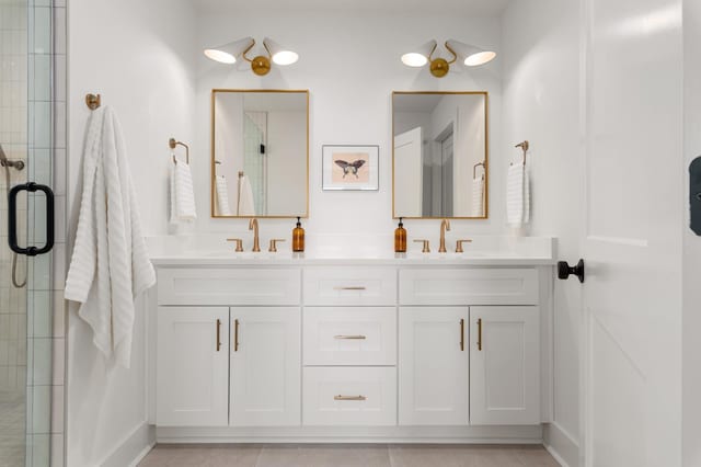 full bath featuring double vanity, a sink, tile patterned floors, and tiled shower