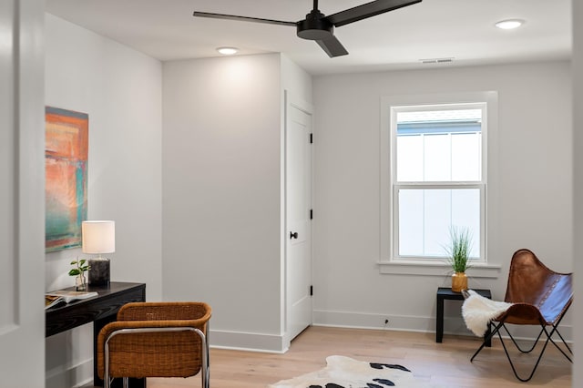 sitting room with plenty of natural light, a ceiling fan, light wood-style flooring, and visible vents