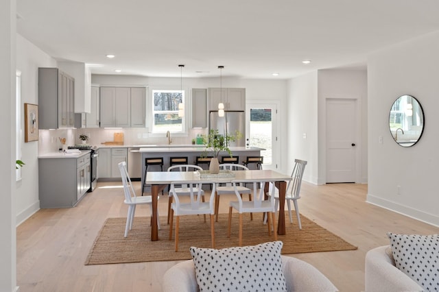 dining area with recessed lighting, baseboards, and light wood-type flooring