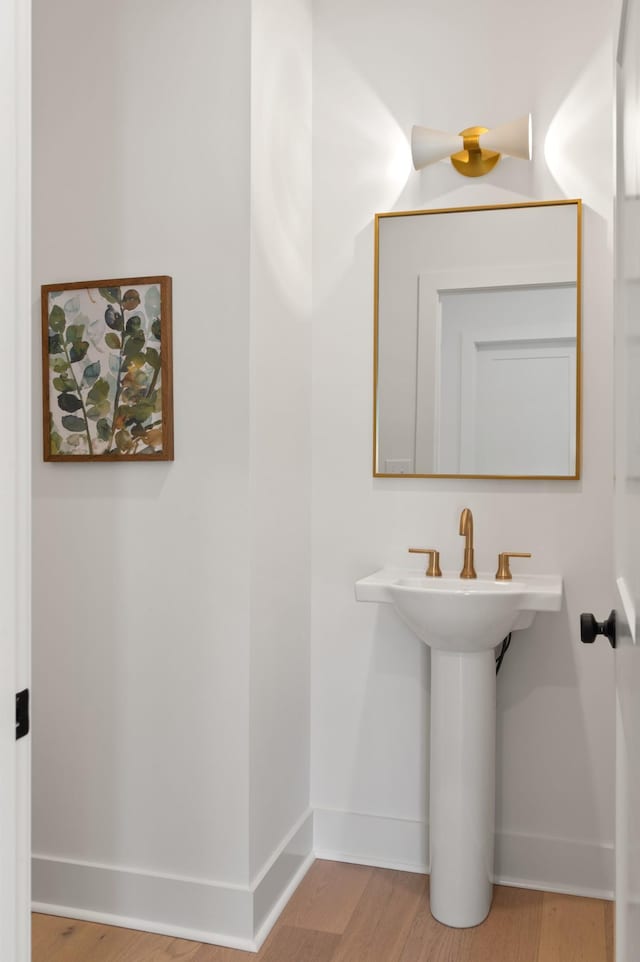 bathroom with baseboards and wood finished floors