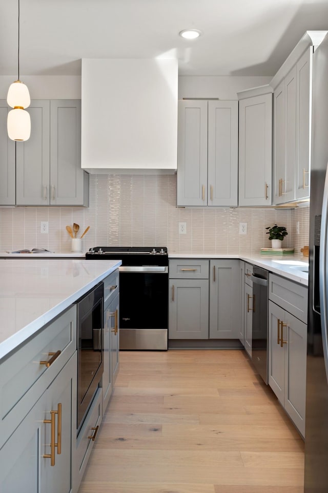 kitchen featuring appliances with stainless steel finishes, gray cabinets, and tasteful backsplash