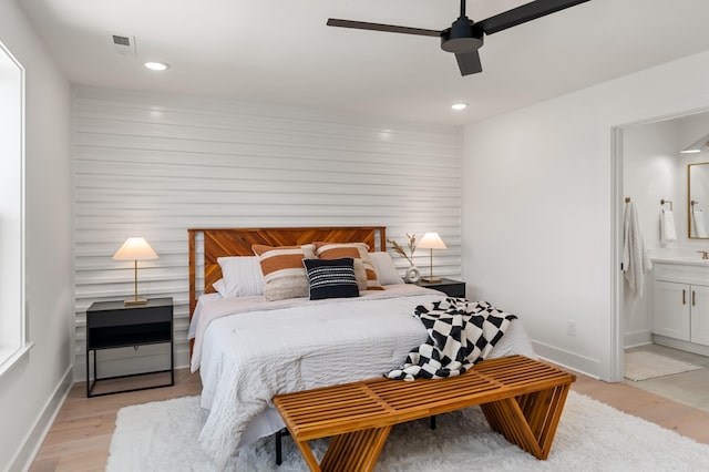 bedroom featuring light wood-type flooring, connected bathroom, baseboards, and recessed lighting