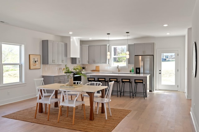 dining room with recessed lighting, baseboards, and light wood-style floors