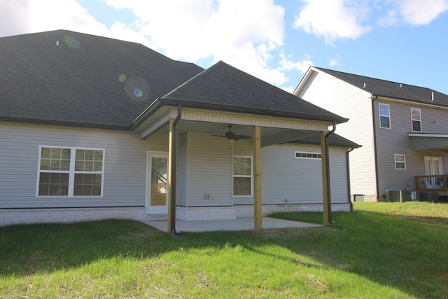 back of property featuring ceiling fan, a patio area, central air condition unit, a yard, and a shingled roof