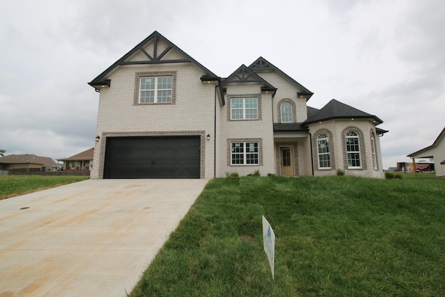 view of front of home featuring brick siding, an attached garage, driveway, and a front lawn