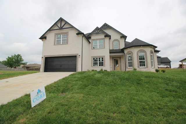 view of front facade featuring brick siding, a garage, a front yard, and concrete driveway