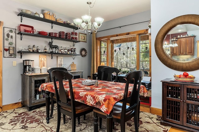 dining area with an inviting chandelier, bar area, and light wood-type flooring