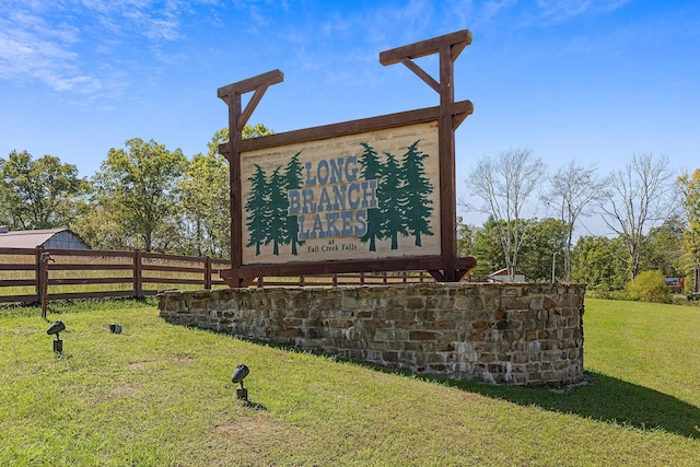 community sign with a lawn and fence