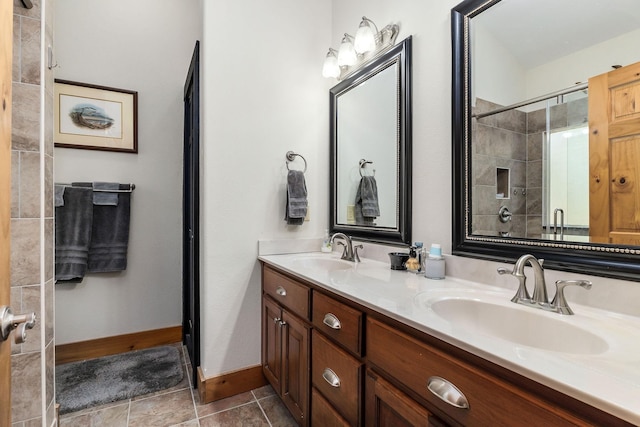 full bathroom featuring double vanity, baseboards, tiled shower, and a sink
