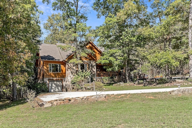 view of front of house featuring an attached garage, concrete driveway, and a front yard