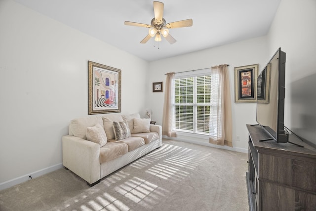 living room with light colored carpet, baseboards, and ceiling fan