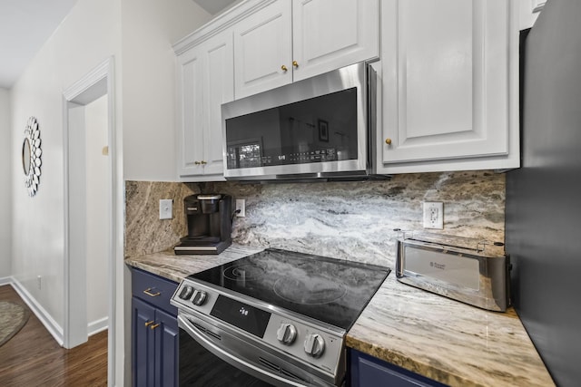 kitchen featuring dark wood-type flooring, white cabinets, blue cabinets, appliances with stainless steel finishes, and backsplash