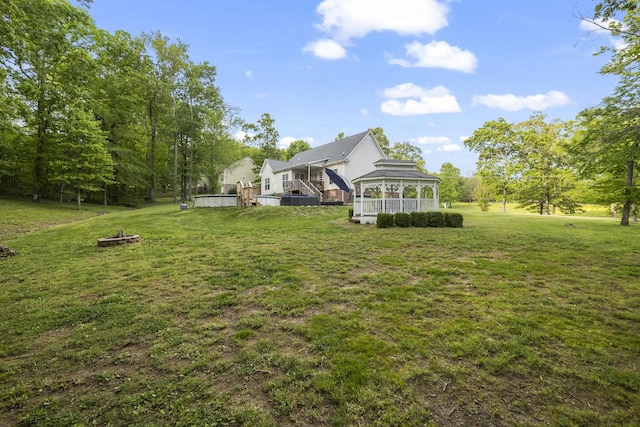 view of yard with a fire pit, a sunroom, and a wooden deck