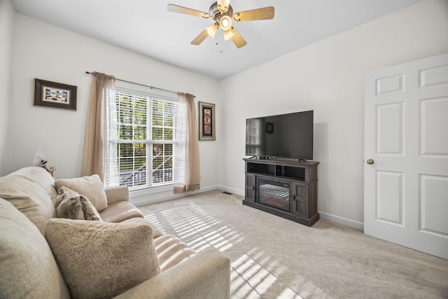 carpeted living area featuring a ceiling fan and baseboards