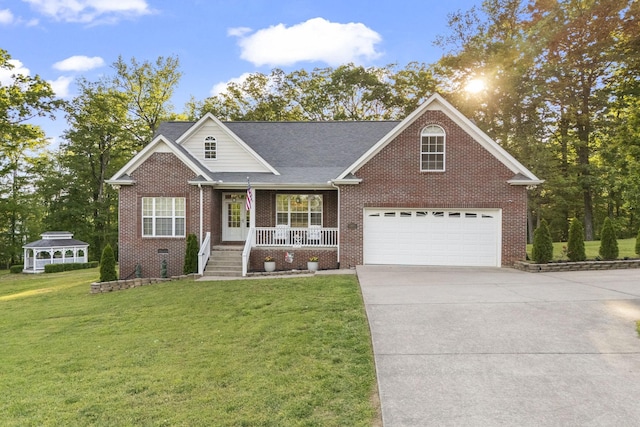 view of front of property with a front lawn, a gazebo, brick siding, a porch, and driveway