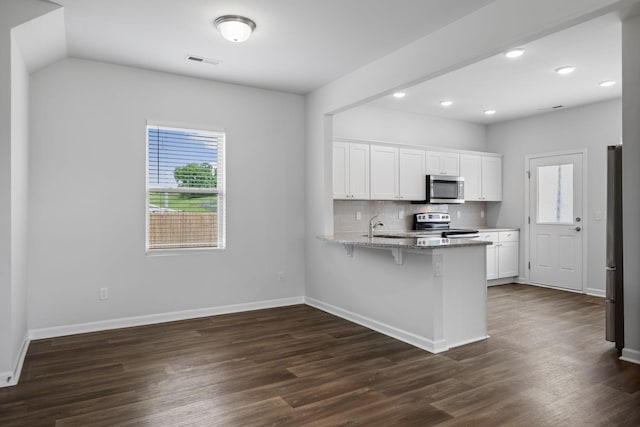 3021 Posada Ct, Spring Hill, TN 37174 - kitchen featuring visible vents, white cabinets, a peninsula, dark wood-style floors, and stainless steel appliances