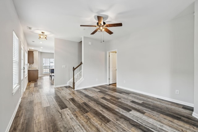 100 Bergen Dr, Spring Hill, TN 37174 - unfurnished living room with visible vents, baseboards, ceiling fan, dark wood-style floors, and stairway
