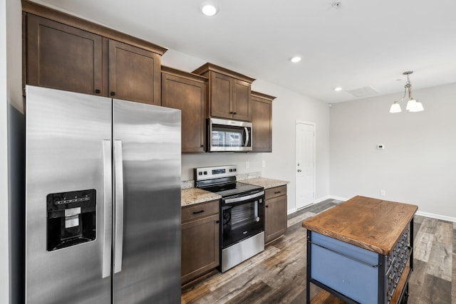 100 Bergen Dr, Spring Hill, TN 37174 - kitchen with dark brown cabinetry, dark wood-style flooring, appliances with stainless steel finishes, light stone countertops, and baseboards