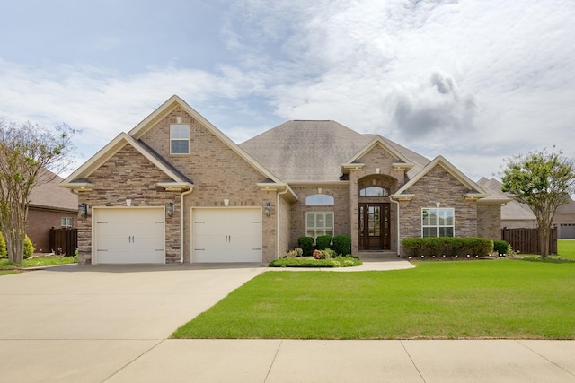 1206 Woodridge Ct, Florence, AL 35630 - view of front of home featuring fence, stone siding, concrete driveway, and a front yard