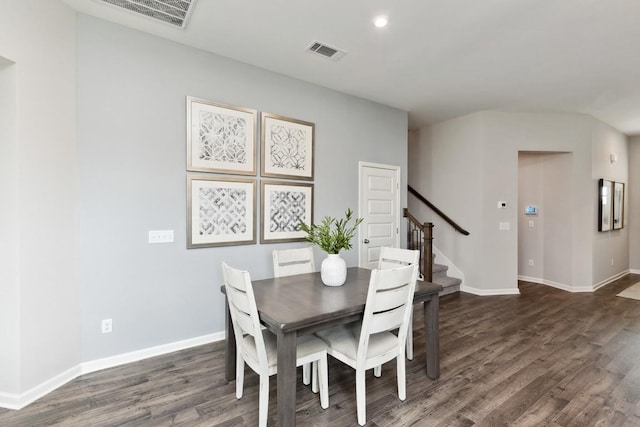 dining area featuring visible vents, baseboards, wood finished floors, and stairway