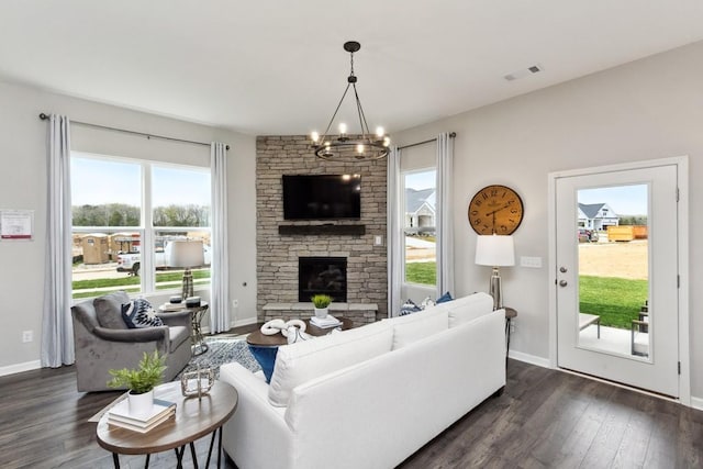 living room with visible vents, dark wood-style flooring, a notable chandelier, and a wealth of natural light