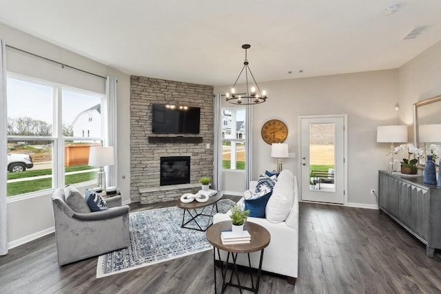 living area with dark wood-style flooring, baseboards, an inviting chandelier, and visible vents