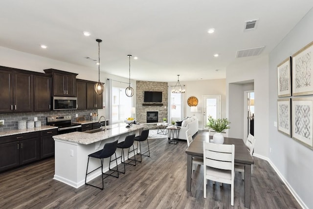 kitchen featuring appliances with stainless steel finishes, a sink, visible vents, and a fireplace