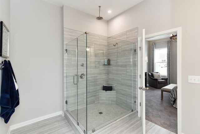 ensuite bathroom with recessed lighting, baseboards, ensuite bathroom, and a stall shower