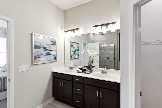ensuite bathroom featuring double vanity, a shower stall, a sink, and ensuite bath