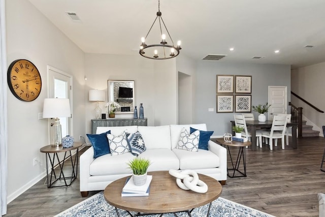 living room with a notable chandelier, stairs, recessed lighting, baseboards, and wood finished floors
