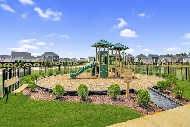 community playground featuring a yard, fence, and a residential view
