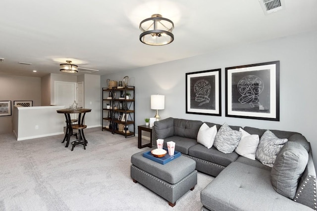 carpeted living area featuring baseboards and visible vents