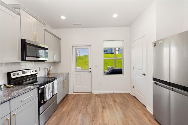 3294 Holiday Ln, Columbia, TN 38401 - kitchen featuring decorative backsplash, visible vents, light wood-type flooring, stone counters, and stainless steel appliances