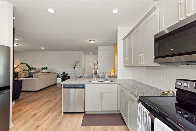 3294 Holiday Ln, Columbia, TN 38401 - kitchen with light stone countertops, appliances with stainless steel finishes, a sink, a peninsula, and open floor plan