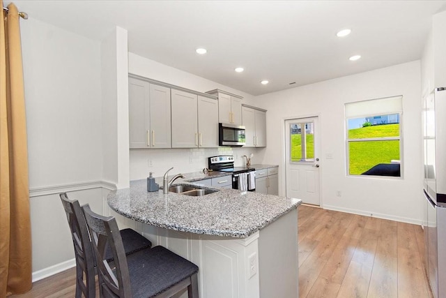 3294 Holiday Ln, Columbia, TN 38401 - kitchen featuring a breakfast bar, light stone countertops, recessed lighting, a sink, and stainless steel appliances