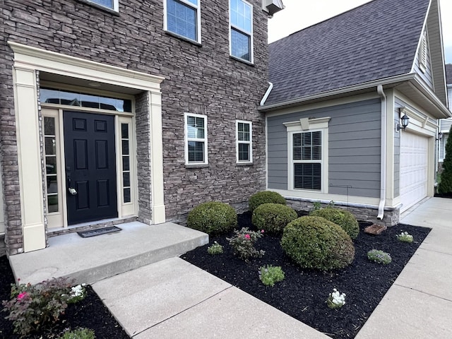 820 Turnbo Dr, Gallatin, TN 37066 - view of exterior entry featuring a shingled roof, an attached garage, driveway, and stone siding