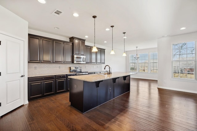 820 Turnbo Dr, Gallatin, TN 37066 - kitchen with tasteful backsplash, a sink, a breakfast bar area, stainless steel appliances, and dark wood-type flooring