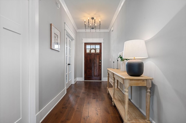 entryway with baseboards, an inviting chandelier, ornamental molding, and dark wood-type flooring