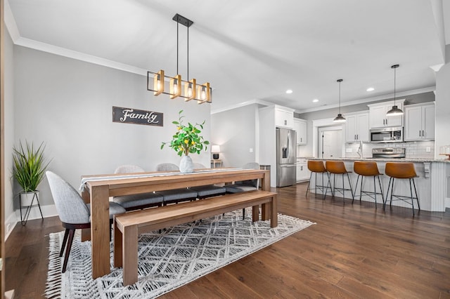 dining room with ornamental molding, dark wood-style flooring, recessed lighting, and a notable chandelier