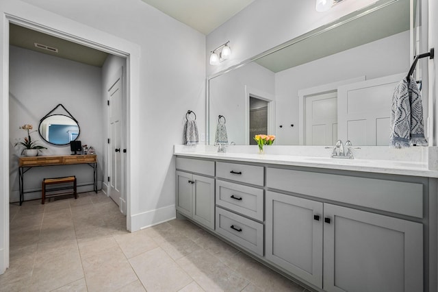 bathroom featuring a sink, double vanity, tile patterned floors, baseboards, and visible vents