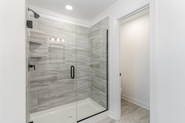 bathroom featuring recessed lighting, baseboards, a stall shower, and toilet