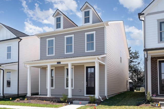 view of front facade featuring central air condition unit, covered porch, and a front yard