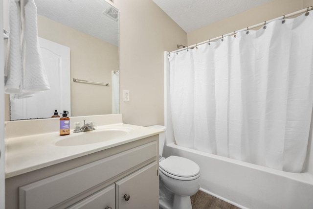 bathroom with vanity, toilet, a textured ceiling, wood finished floors, and visible vents