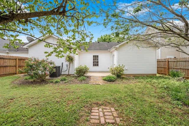 rear view of property with a patio, a fenced backyard, a yard, and cooling unit