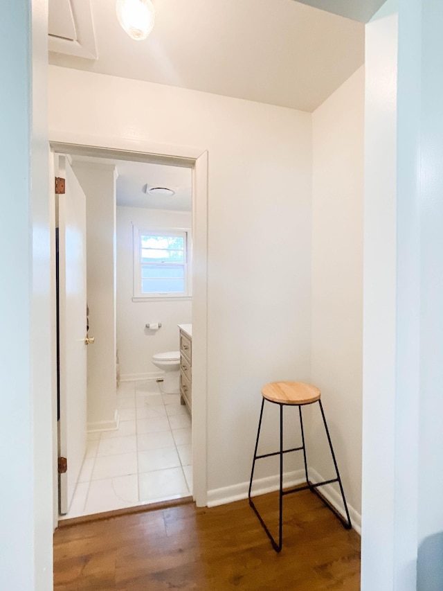 bathroom with toilet, baseboards, wood finished floors, and vanity