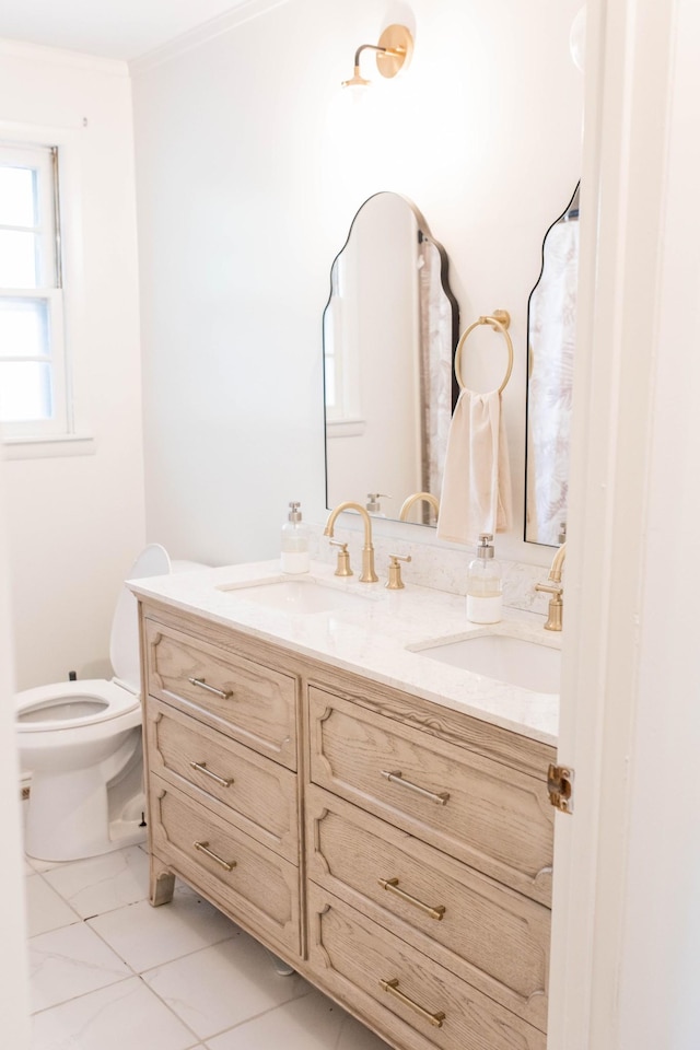bathroom with double vanity, a sink, and toilet