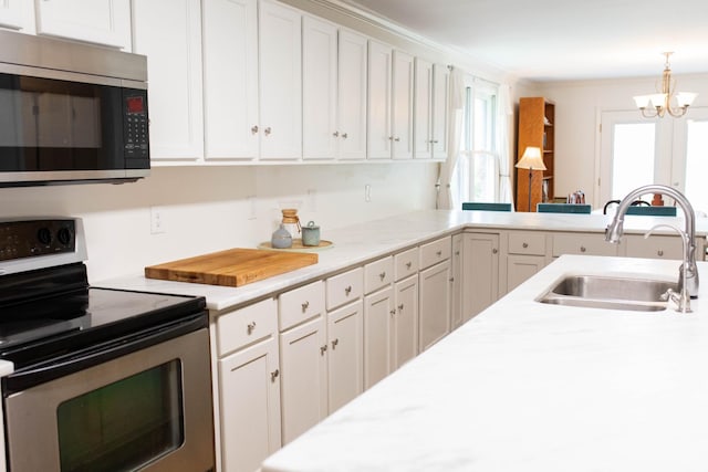 kitchen with a sink, light countertops, stainless steel appliances, and white cabinetry