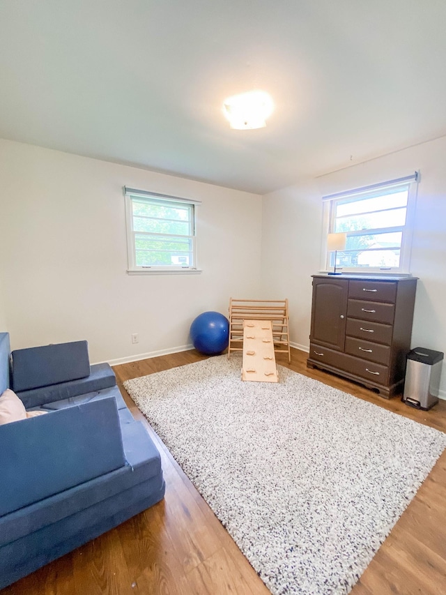 workout area with baseboards and wood finished floors