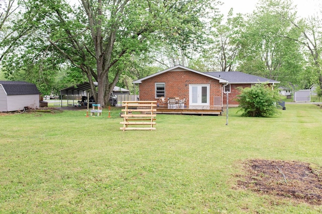 view of yard with an outbuilding, a wooden deck, a carport, and a shed